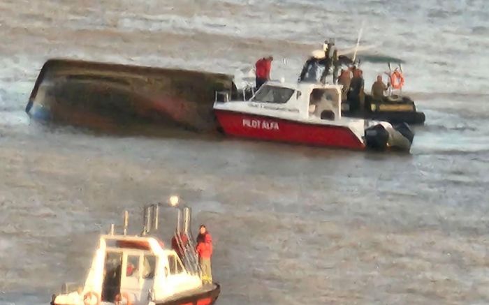 Itajaí - Barco pesqueiro com quatro tripulantes vira perto do ferry boat no rio Itajaí-açu