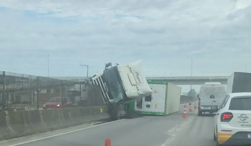 Carreta tomba na BR-101 fica presa em mureta e provoca 8km de fila em Porto Belo 