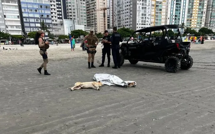 Morador de rua morre afogado na praia de Balneário Camboriú e dog dele fica desolado na praia