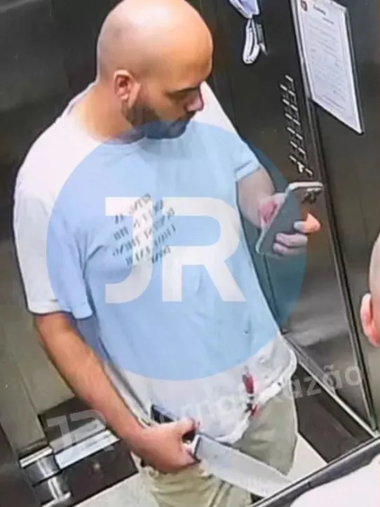 Câmera flagra jornalista com faca e mancha de sangue na camisa no elevador da casa do ex 