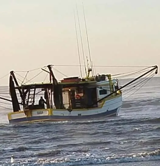 Barco pesqueiro de Balneário Camboriú encalha na praia de Ilha Comprida no litoral sul de São Paulo