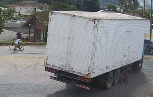 Milagre: Ciclista é atropelada e fica centímetros de ser esmagada por rodado traseiro de caminhão