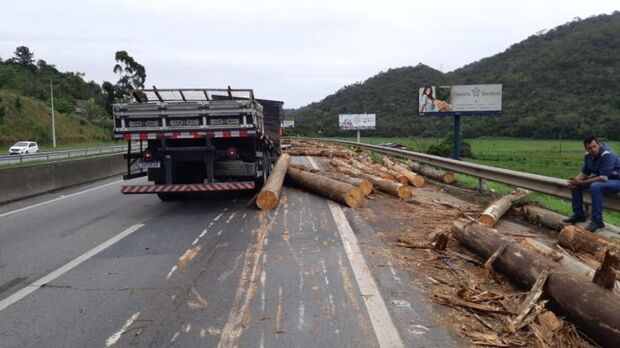 Trãnsito Lento: Pneu estoura e caminhão derruba carga de madeira na BR-101 em Itajaí