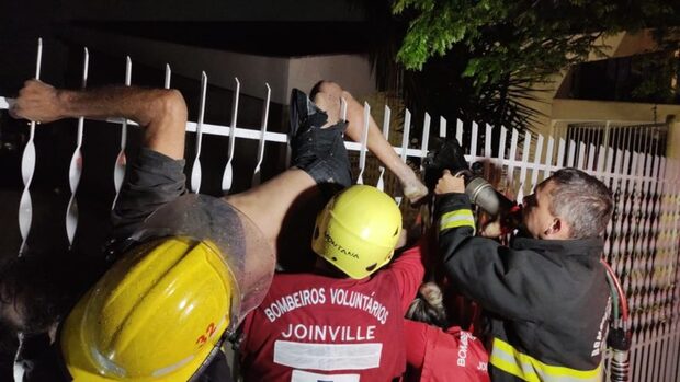 Dorminhoco: Homem tenta pular cerca de igreja e fica engatado na grade em Joinville