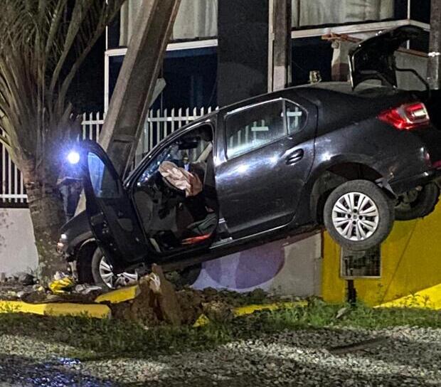 Na Variante – Motorista bate em poste e carro fica trepado em muro de um estabelecimento comercial na SC-414 em Balneário Piçarras